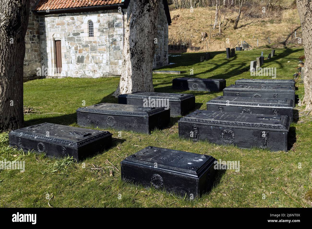 Gusseiserner Sarg als Grabmarker in Erinnerung an die Familie Ravn aus dem 19.. Jahrhundert auf dem Friedhof St. Jetmund`s aus dem 12.. Jahrhundert in Åheim, Vanylven, Norwegen Stockfoto